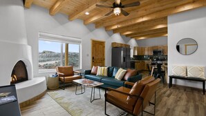 Un salón amplio con chimenea, muebles de cuero y vistas al exterior.