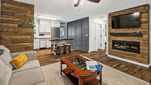 A modern living room with a sofa, coffee table, and a fireplace. - Trail Side in the Heart of Winona Lake (Winona Lake)
