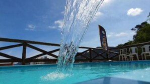 Una piscina con acqua cristallina e una cascata.