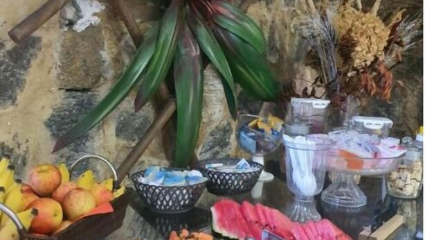 Un buffet con diverse varietà di frutta e verdura, tra cui mele, anguria e carote a fette.