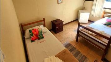 A hotel room with a bed, a TV, a small table, and a chair.