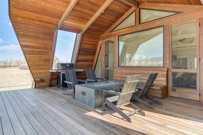 Enjoy the serene views from this outdoor deck with a fire pit and comfortable seating.