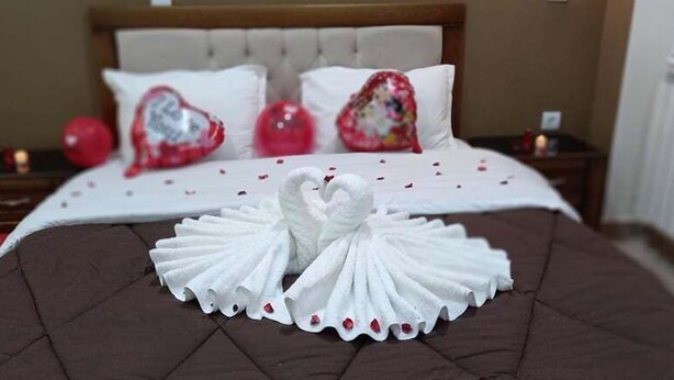 A bed with a heart-shaped towel arrangement and two heart-shaped pillows. - Hotel Salsabil Naoui (Djelfa)