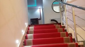 A staircase with red carpeted steps and a metal railing. - Hotel Salsabil Naoui (Djelfa)