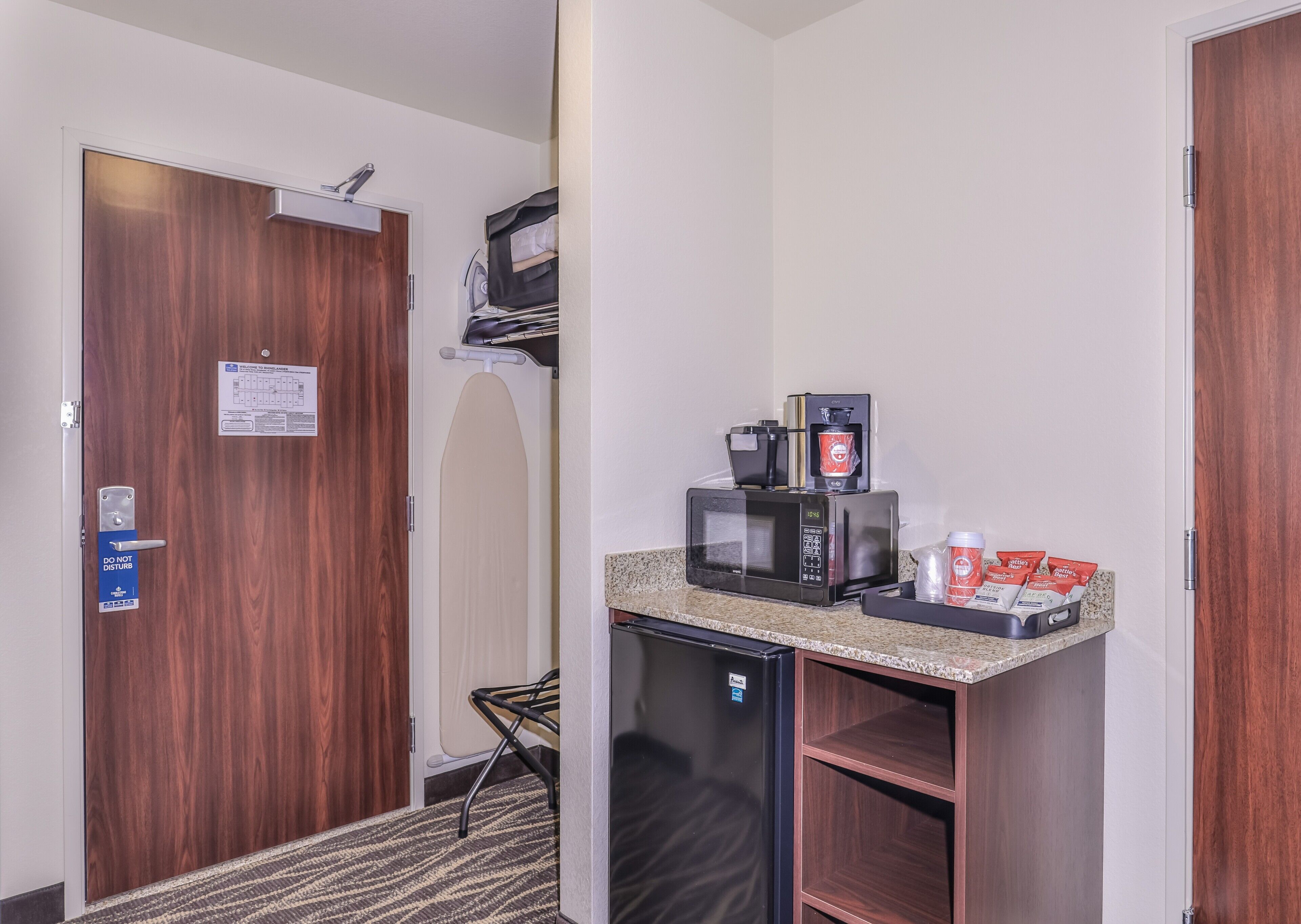 A compact kitchenette with a microwave, coffee maker, and a small refrigerator.
