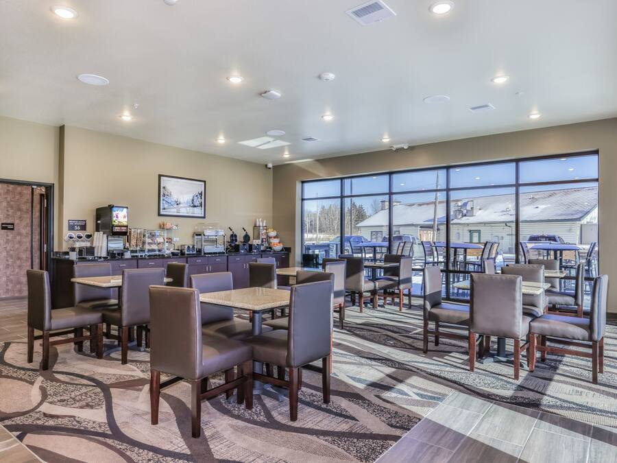 A spacious indoor area with multiple seating arrangements, a counter with various amenities, and large windows offering a view of the outside.