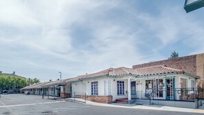 A row of single-story buildings with a consistent architectural style, featuring a tiled roof and a central entrance with a door and windows. - The Alameda Motel San Jose (San Jose)