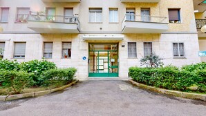 An apartment building with a green entrance door, multiple windows, and balconies. - Four stops from the center of Milan, you will have all the comforts of home! (Milano)