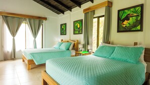 A hotel room with two beds, a wooden headboard, a nightstand, and a window with curtains. - Villa El Tucán (Bijagua)