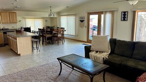 Un área de estar amplia con una mesa de comedor, un sofá y una cocina al fondo.