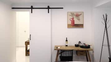 A modern room with a sliding door, a dining table with a bottle of wine, a chair, and a painting on the wall.