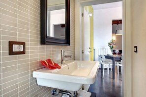 A bathroom with a white sink, a mirror, and a towel rack.