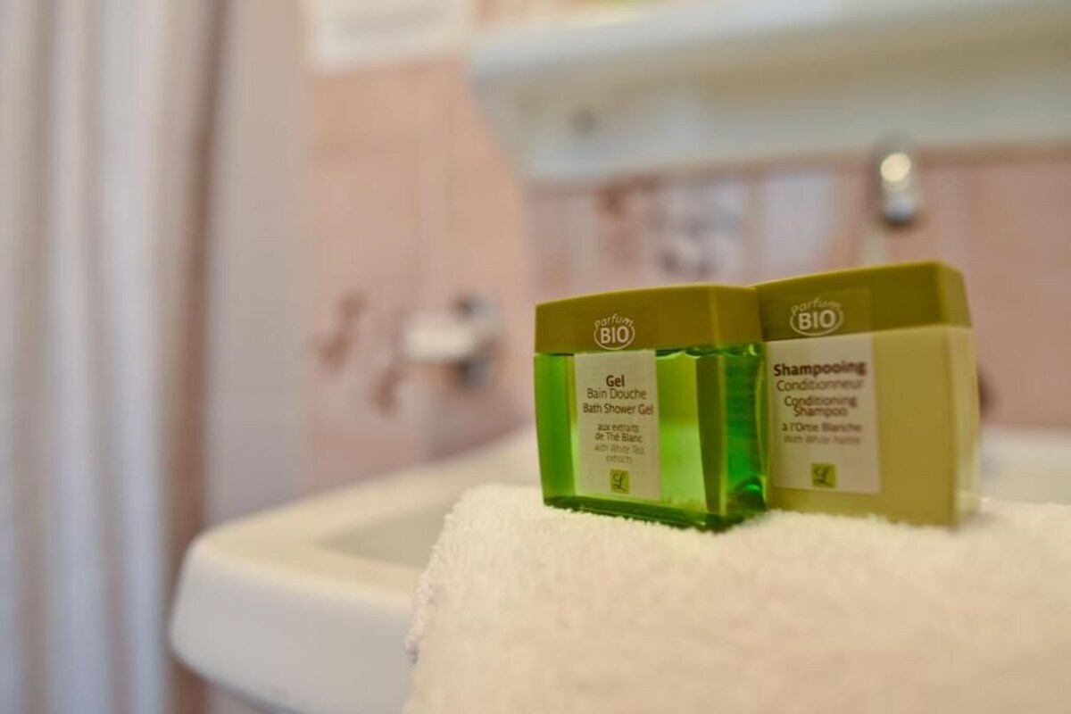 Two bottles of bath products on a bathroom sink.