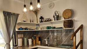 Una cocina moderna con una isla central, luces colgantes y taburetes de madera.