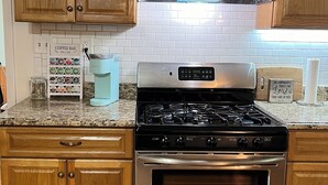 A kitchen with wooden cabinets, a stainless steel stove, and a coffee station. - Peaceful retreat, 20 minutes from Gettysburg and close to the Appalachian Trail. (Aspers)