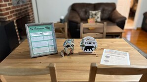 A wooden table with a welcome sign, a bear-shaped sign, and a menu. - Peaceful retreat, 20 minutes from Gettysburg and close to the Appalachian Trail. (Aspers)