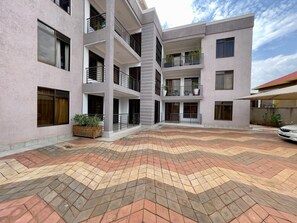 A multi-story building with a courtyard featuring a patterned tile floor.