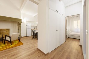 A modern apartment with a dining area, kitchen, and a bedroom with a window. - Uffizi 3 bedrooms in Florence by Mmega (Firenze)