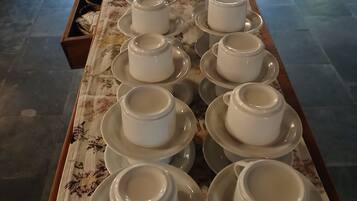 Una mesa con varios tazas y platillos blancos dispuestos ordenadamente.