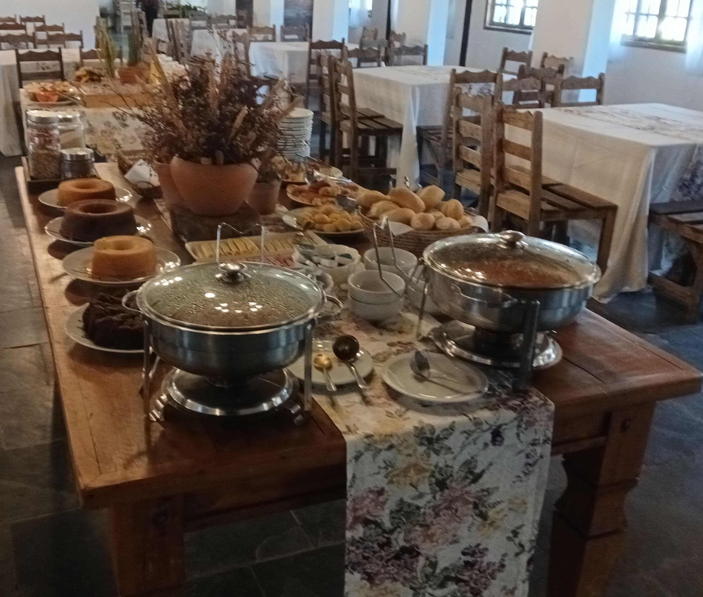 A buffet setup with various dishes and a floral tablecloth.