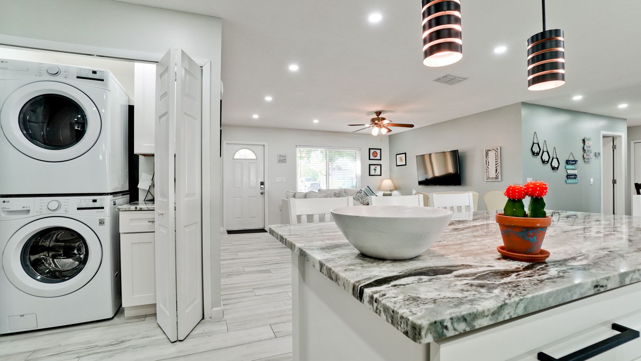 A modern kitchen with a large island, built-in appliances, and a ceiling fan.