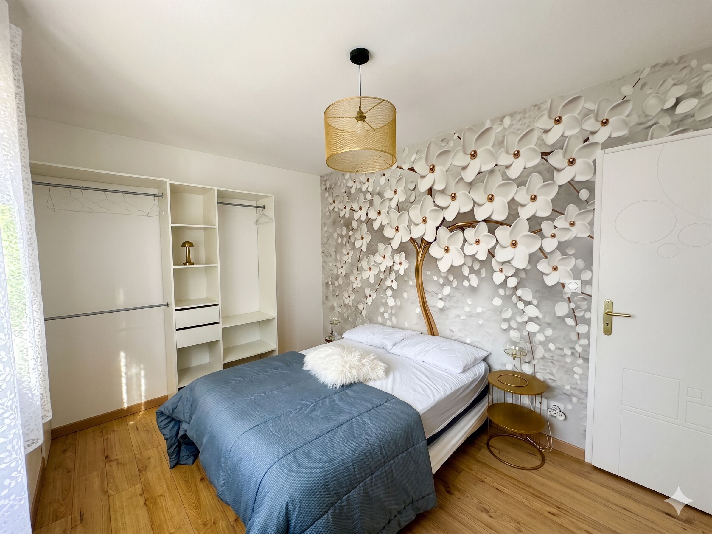 Una camera da letto con un letto, un armadio, una lampada a parete e una porta con maniglia.
