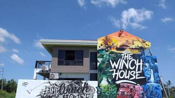 Un edificio con un mural en la fachada, un letrero que dice "The Winch House" y otro letrero que dice "The Animal House".