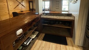 Una cocina moderna con armarios de madera, estufa integrada y encimera con lavabo.