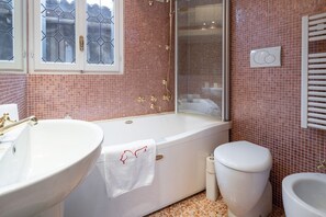 A bathroom with a large white bathtub, a white toilet, and a white sink. - two bedrooms apartment in San Marco (Venezia)