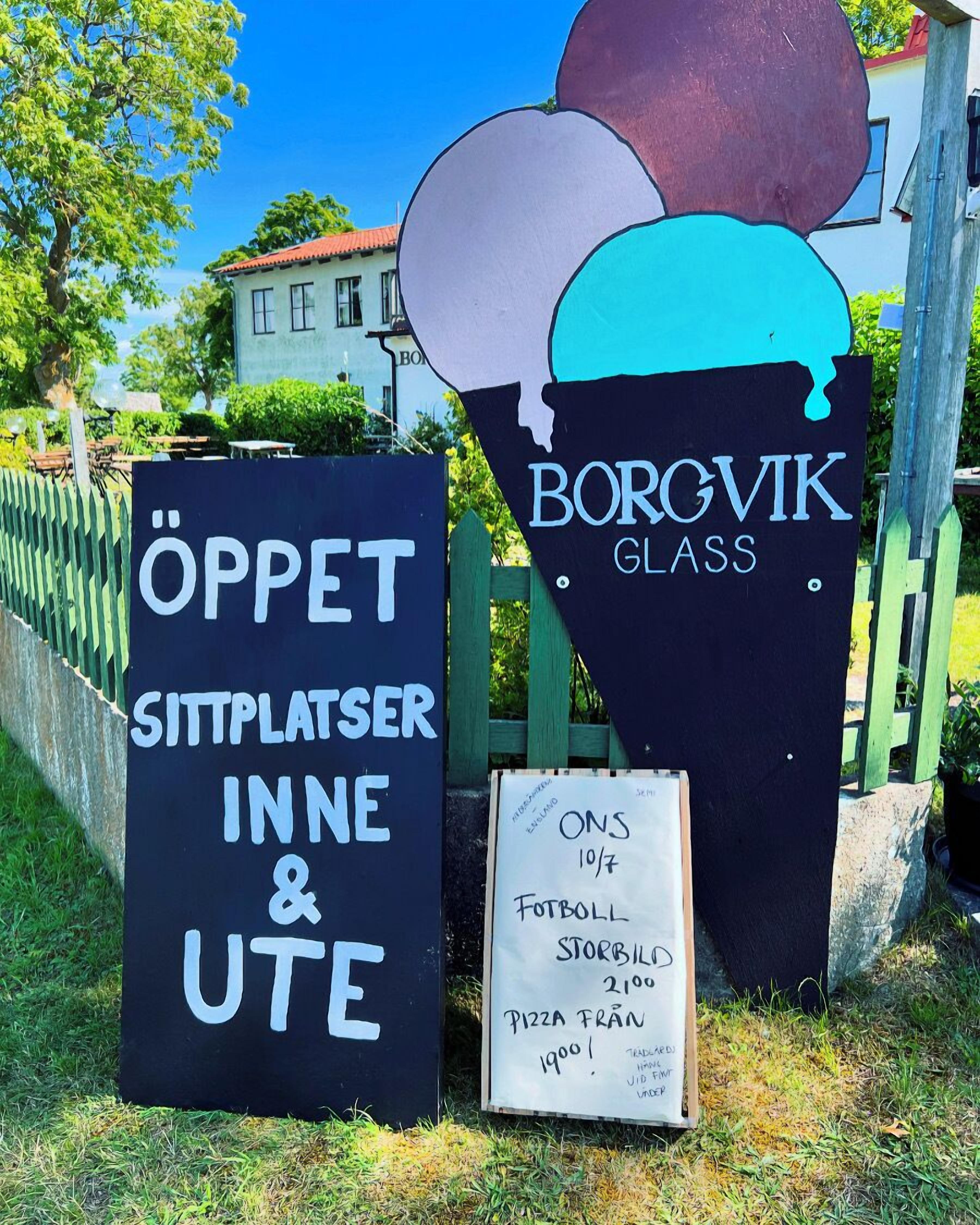 A sign for BORGVIK GLASS with a menu listing items like onsen, football, storbilde, and pizza.