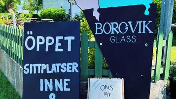 A sign for BORGVIK GLASS with a menu listing items like onsen, football, storbilde, and pizza.