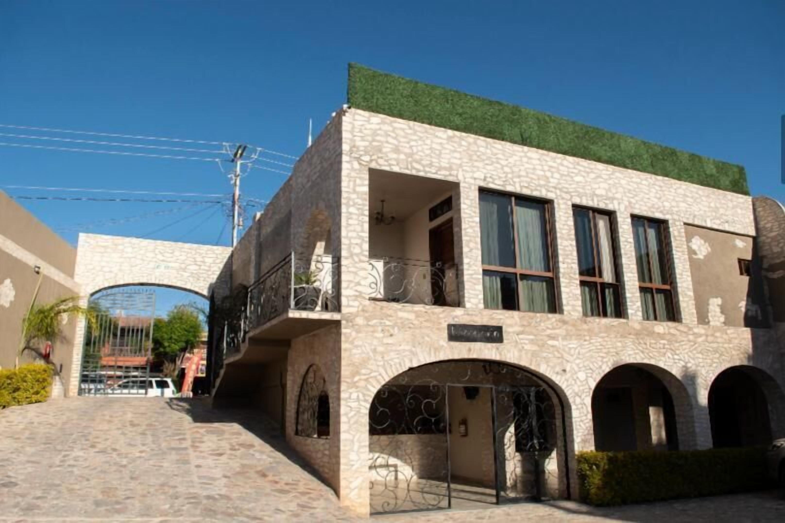 Un bâtiment doté d’une façade en pierre, de nombreux balcons et de portes en arc de cercle.