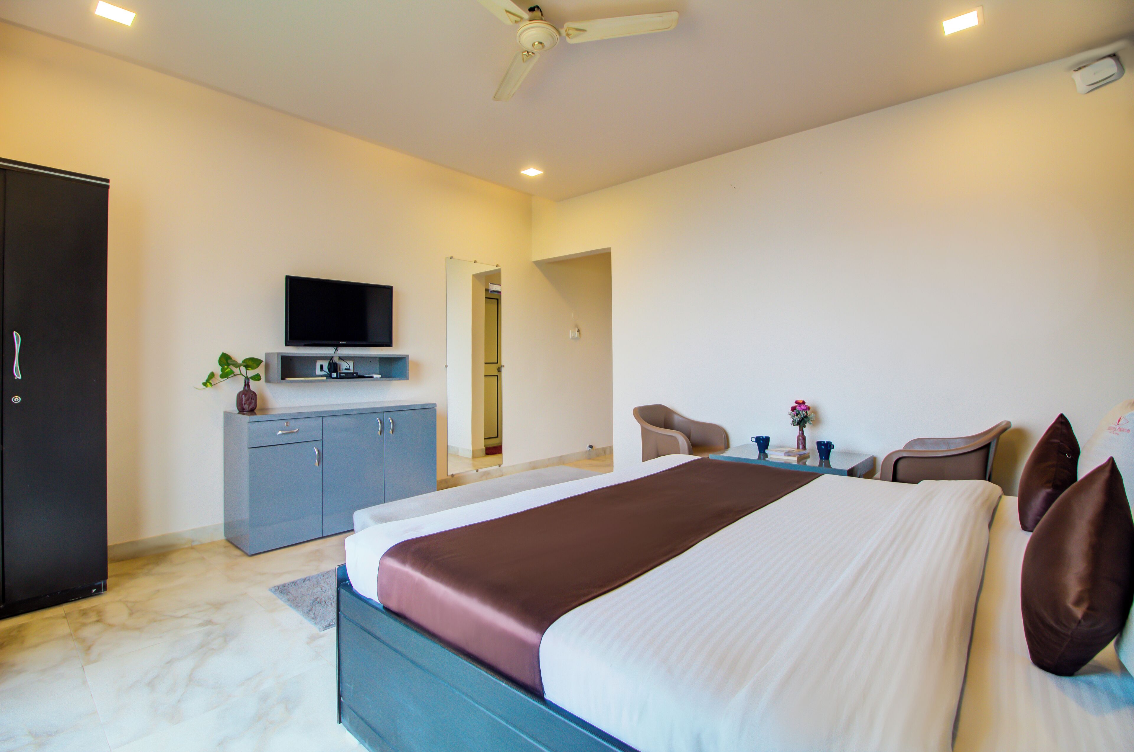 Une chambre d’hôtel moderne équipée d’un grand lit, d’un téléviseur à écran plat, d  ’un bureau et d’une chaise.