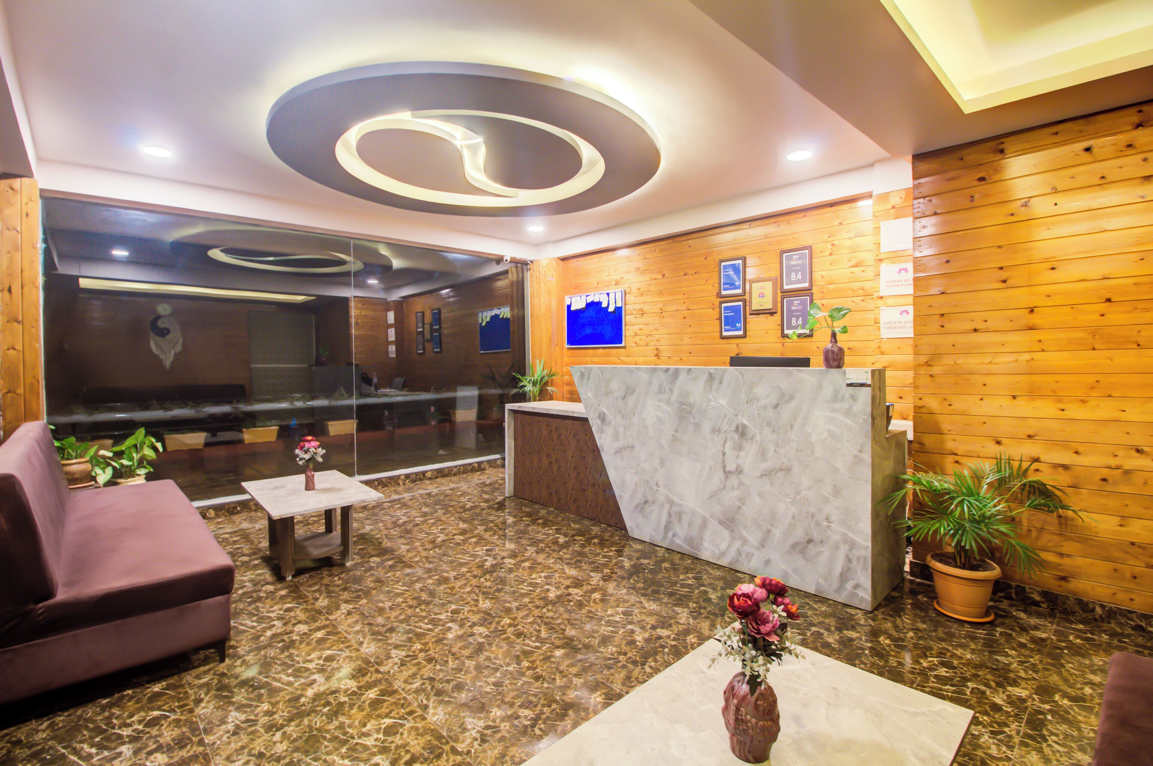 A lobby with a reception desk, seating area, and a large mirror.