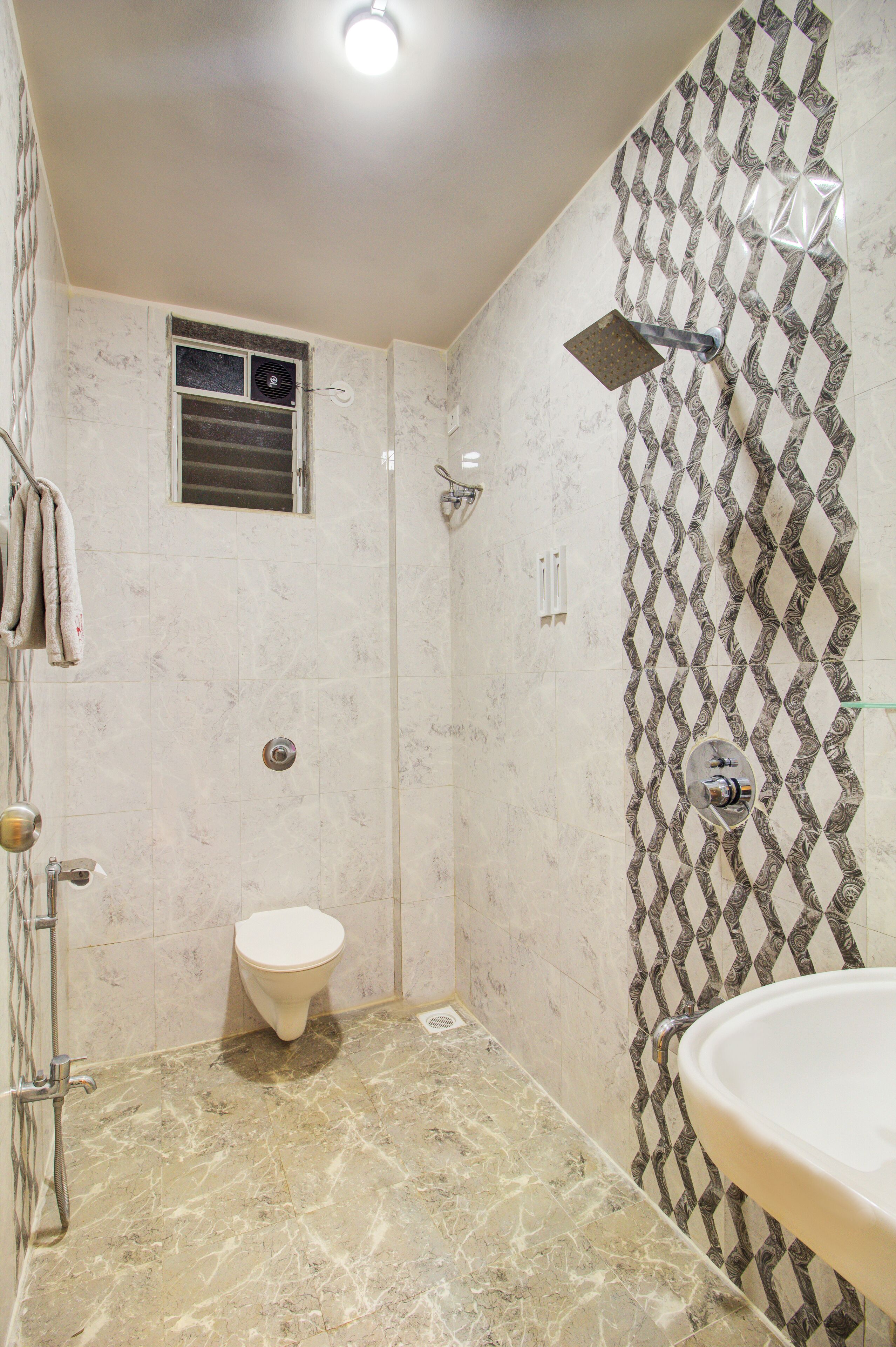 A bathroom with a shower, toilet, and sink.