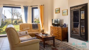 Una sala de estar con sofá, mesa de centro, televisor y aparador de madera.