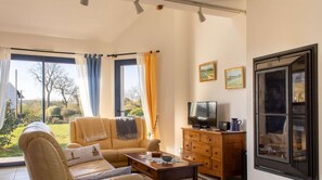 Ein Wohnzimmer mit Sofa, Couchtisch, Fernseher und Holzschrank.