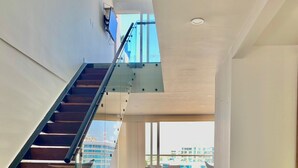 A modern interior with a staircase, a seating area, and a view of the cityscape. - Cartagena Morros Beach and Sea (Cartagena)