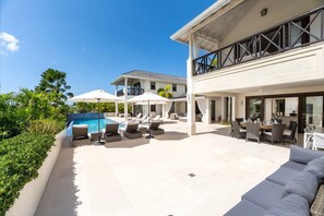 A modern house with a pool, outdoor seating, and a large dining area. - Caribbean Sea Vistas - Infinity House (Westmoreland)