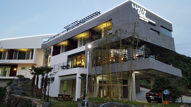 Un edificio moderno de varios pisos con techo plano, ventanas amplias y un balcón.