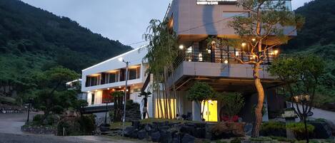 Un edificio moderno de dos pisos con un letrero que dice "767 Family Residence & Pension Bakery & Cafe".
