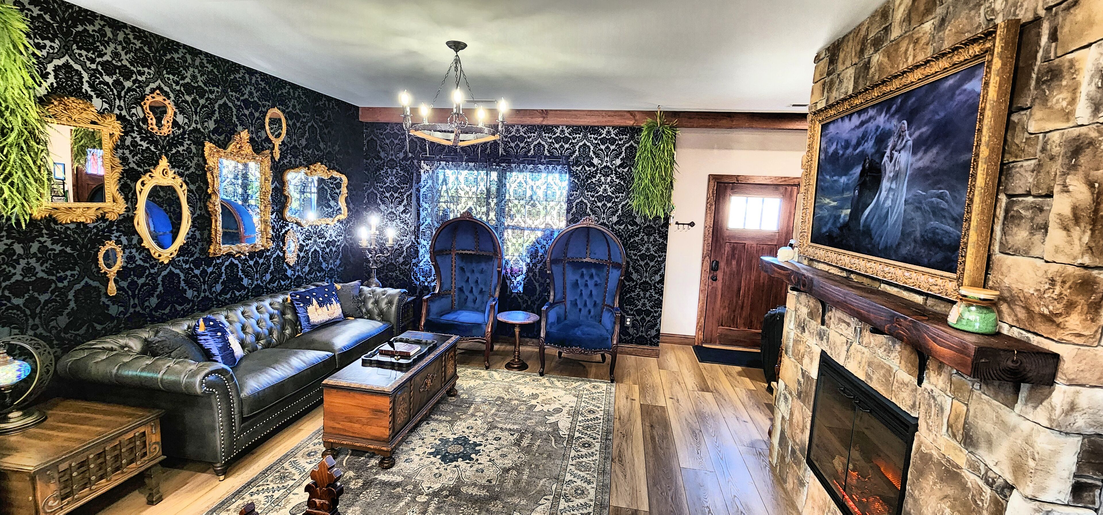 A living room with a fireplace, a sofa, a blue armchair, and a chandelier.