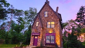 A stone building with a purple door and windows, labeled "Chree Wizards" and "Bils & Bobs". - Three Wizards A NEW magical & unique stay in the Fantastical Forgotten Forest (Kodak)