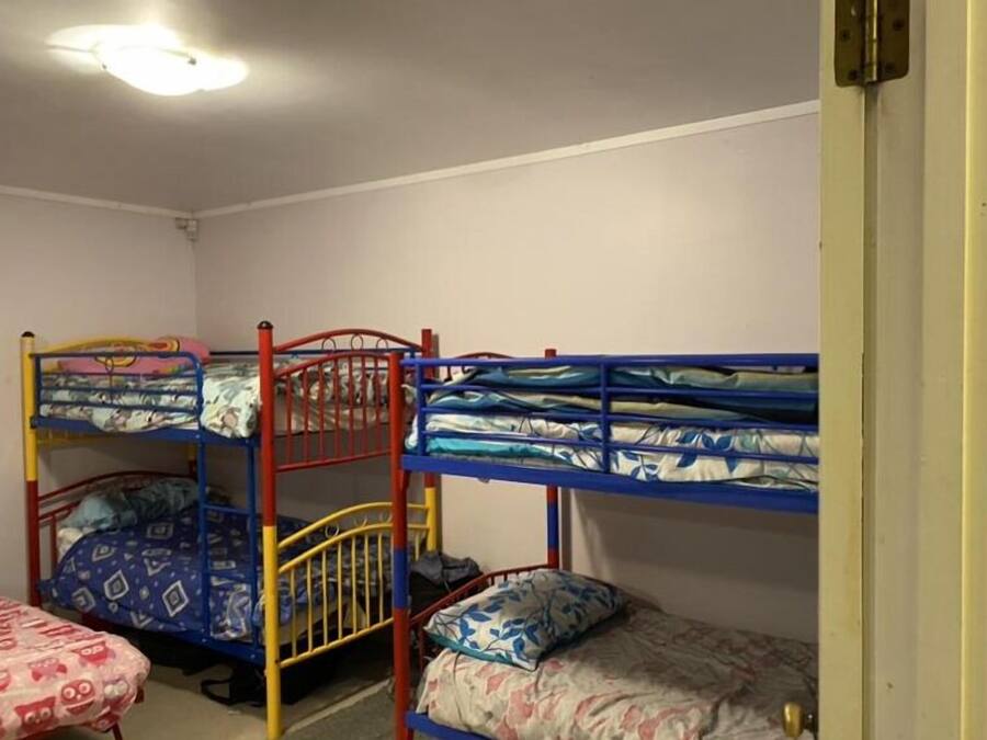 A room with bunk beds, a door, and a ceiling light.