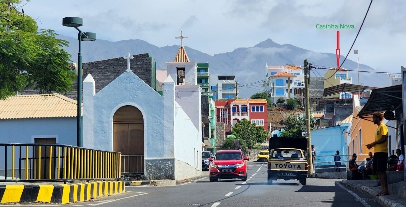 A street view with a church, a Toyota truck, and a mountain in the background.