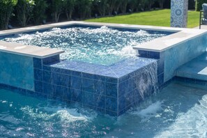 Un jacuzzi rectangulaire avec un intérieur carrelé de couleur bleue et un élément décoratif aquatique.
