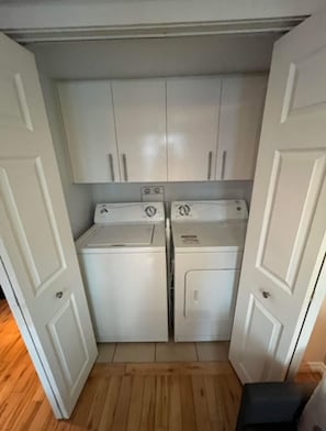 Efficient laundry facilities feature two front-loading washing machines and a dryer.