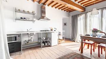 Een moderne keuken met een ingebouwde oven, magnetron en roestvrijstalen planken.