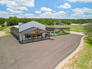 A modern building with a covered patio area, outdoor seating, and a pool. - Perfect Couple’s Getaway in Luckenbach Tx Hot tub Pool (Fredericksburg)
