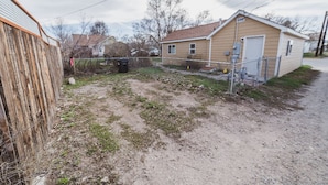 A single-story house with a fenced yard, a garage, and a utility shed.